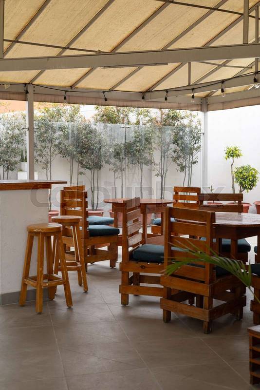 featuring sturdy wooden chairs, ideal for relaxing meals in a natural and inviting atmosphere, restaurant