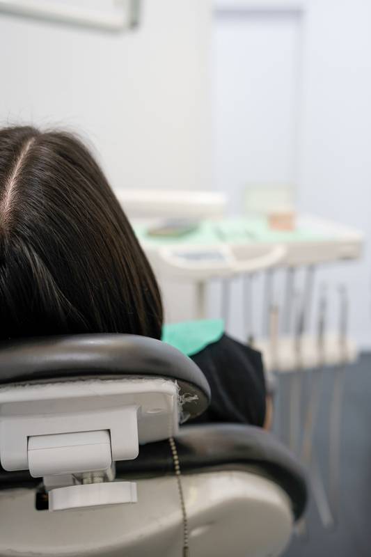 person sitting in the chair of a dental office, medical instrument