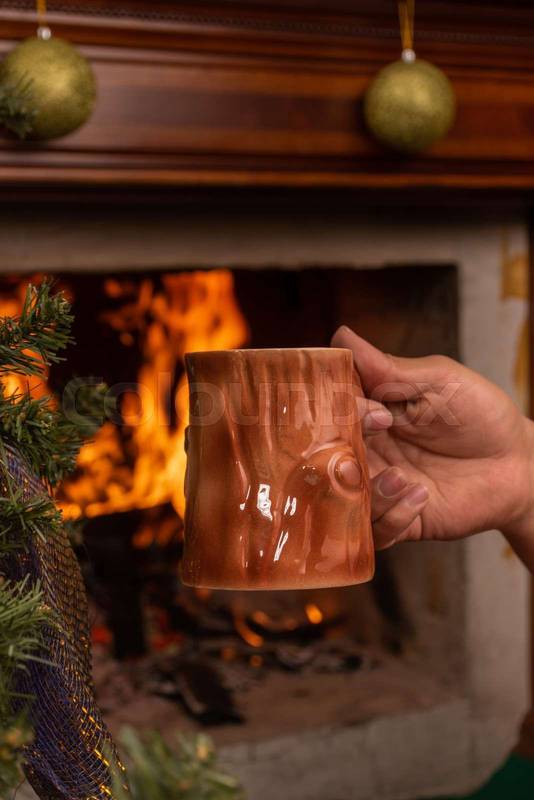 hand holding an original mug with a wooden design, with a hot drink