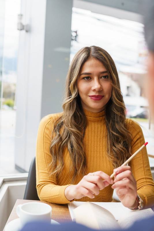 holding a pencil a beauty of young latin woman with blonde hair, with an open book