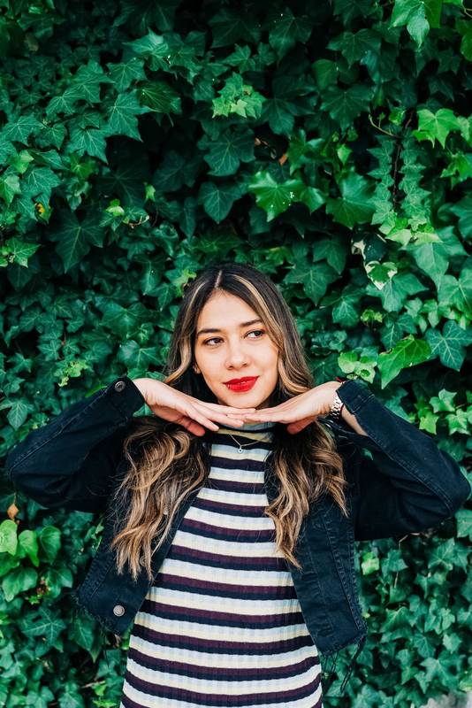 Latin young woman with long, blonde and wavy hair, with makeup highlighting her red lips