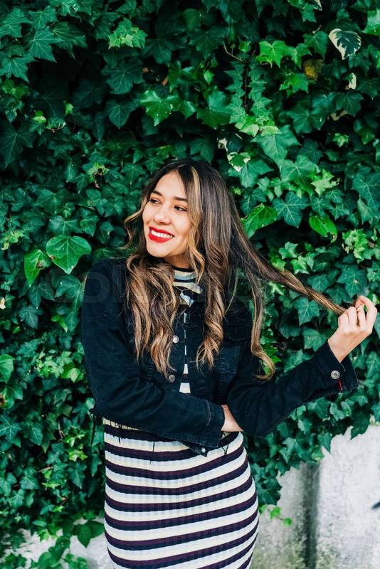 playing with blond, long wavy hair a young latin woman