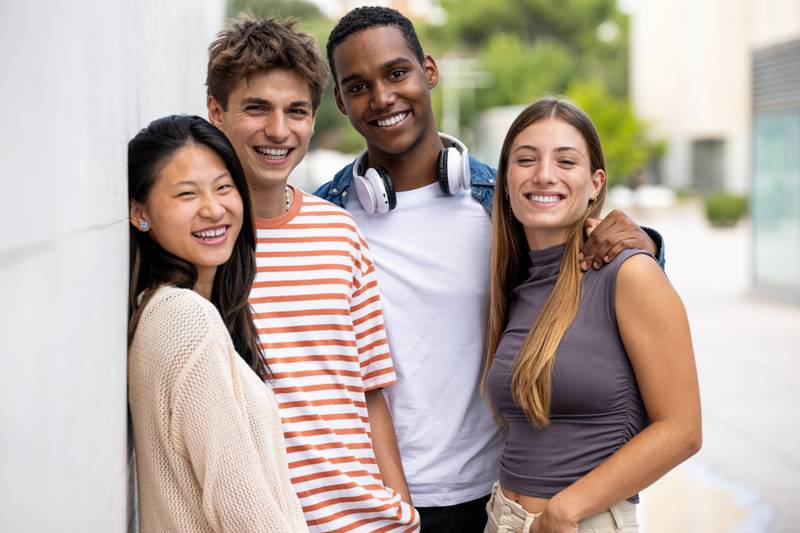 Beautiful young men and women smiling and looking at camera.Diverse group of joyful millennial people staring happy at camera.