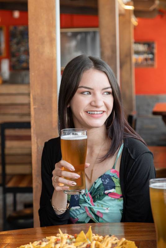 sitting in a restaurant with wooden furniture sitting holding a drink