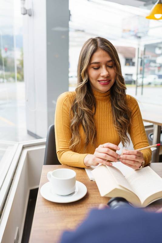 coffee shop in the daytime with a young latin girl with makeup blonde hair smiling