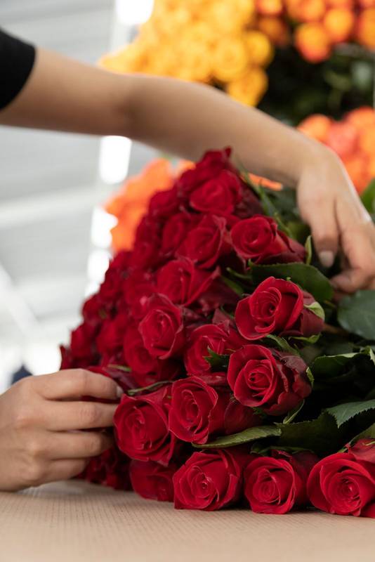 making a floral arrangement with natural red roses