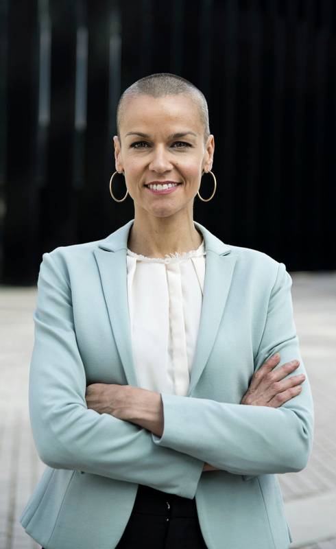 Close up of a female businesswoman with arms folded. Modern style executive looking at camera