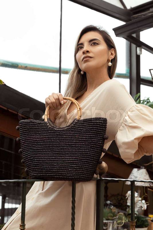 Latin young woman with long hair, wears formal and fashionable clothes accompanied by a bag, lifestyle