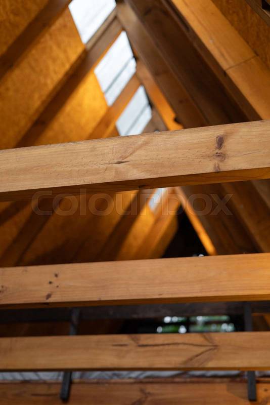 wooden beams create a graceful, triangular roof design inside a tropical glamping cabin