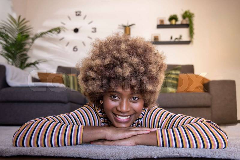 Happy young beautiful woman relaxing at home looking at camera. portrait of smiling female lying on the floor. Lifestyle concept
