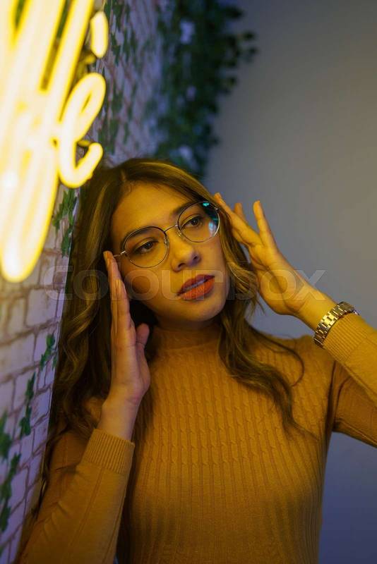 woman with long hair and holding her glasses, natural makeup