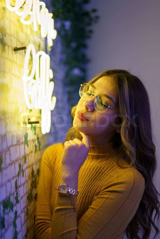 distracted young latin woman with long hair with makeup and glasses