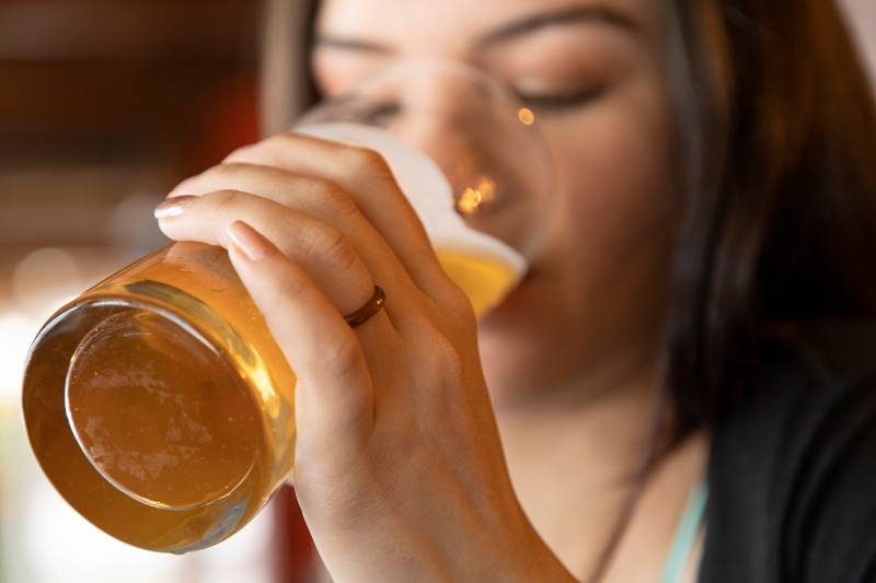 aking a crystal glass with a drink, closeup to the face,