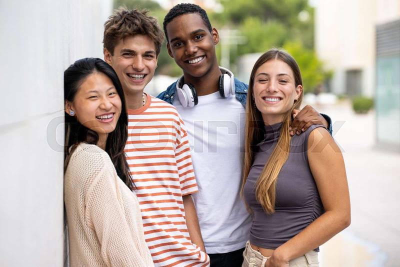 Beautiful young men and women smiling and looking at camera.Diverse group of joyful millennial people staring happy at camera.