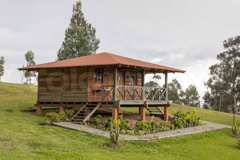landscape with one wooden cabin with balcony, rustic style with garden and grass around it