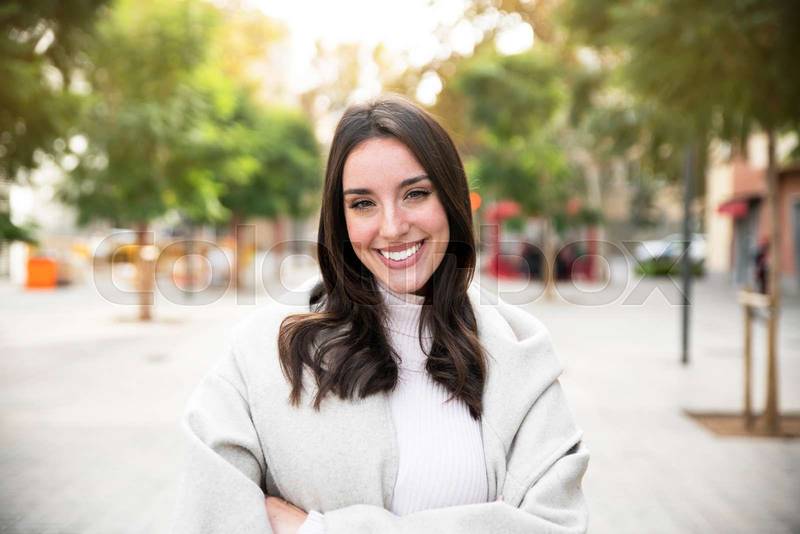 Portrait of young woman smiling happy standing at the city.
