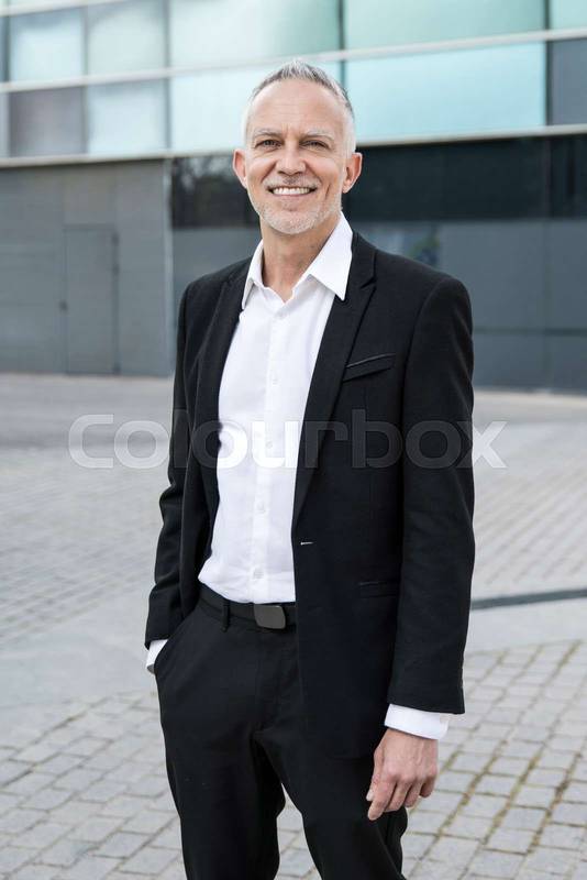 Portrait of a handsome senior businessman standing at outdoors. Mature executive looking confidently into the camera.