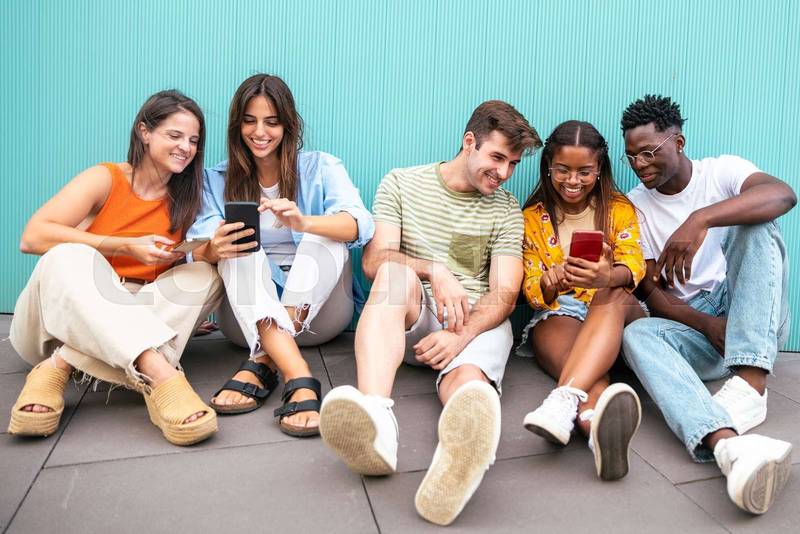five happy young friends looking mobile phone and smiling with the content - happy teenagers with a smartphone - Lifestyle concept