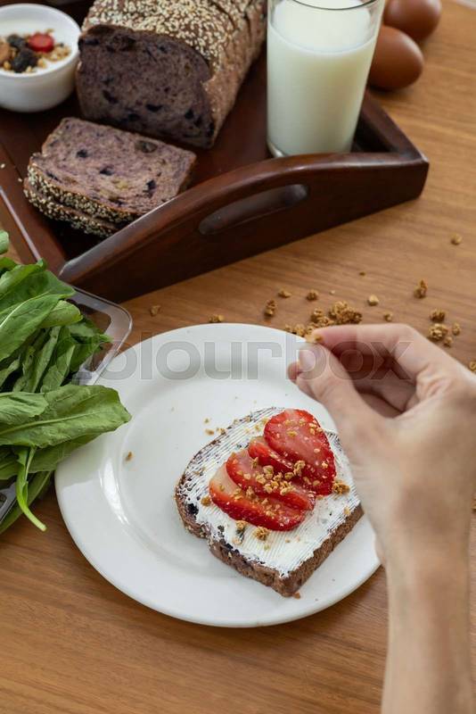 perfectly toasted slice of bread is gently spread with smooth cream cheese, adorned with ripe tomato slices