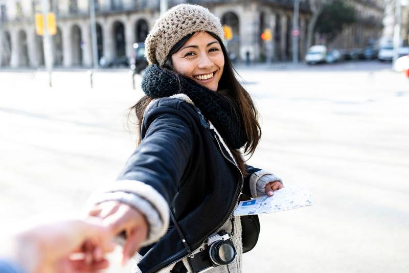 Cheerful young woman holding hands with crop man