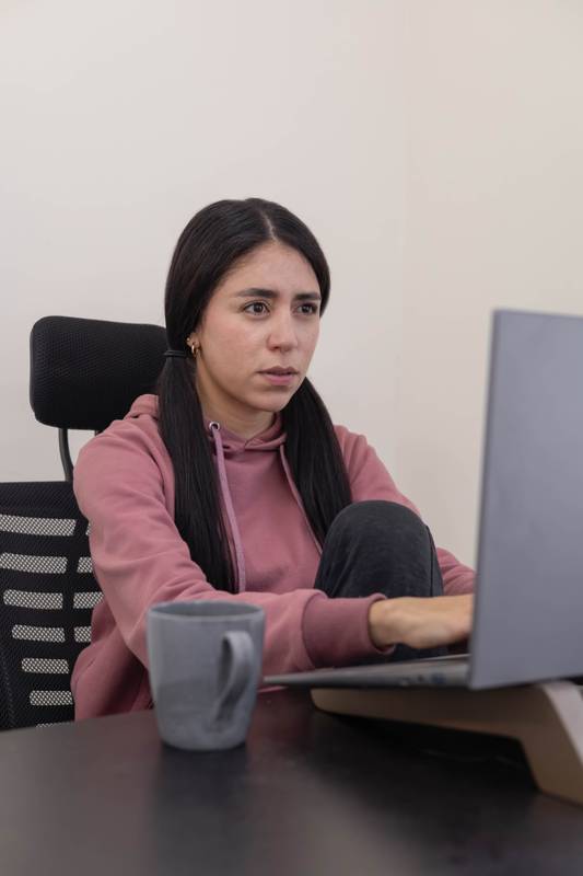 Female employee looking bored at office desk, technolgy