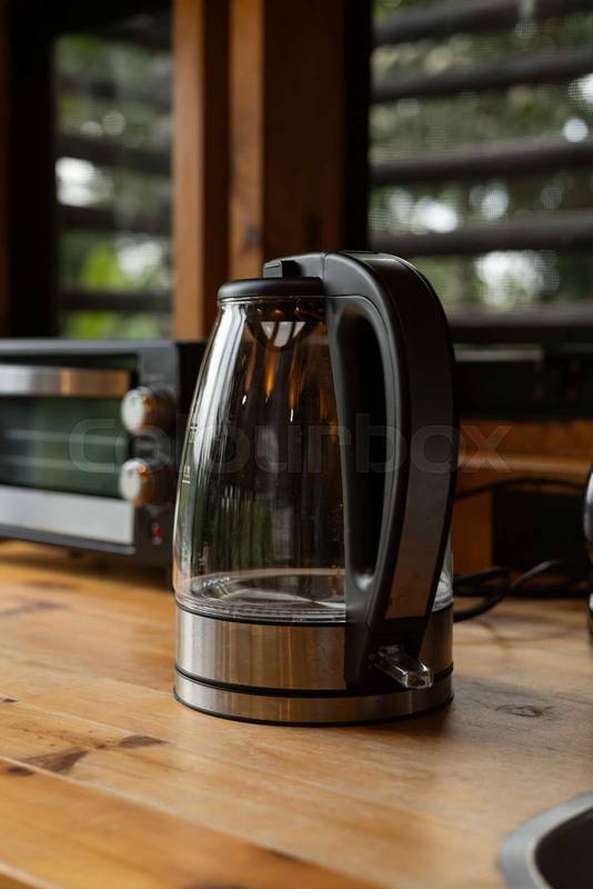 electric coffee maker rests on a wooden surface, kitchen elemnts
