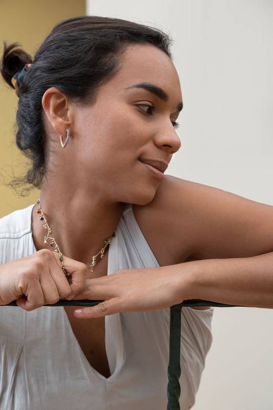 woman naturally, wearing earrings while being relaxed pensive with her face in profile