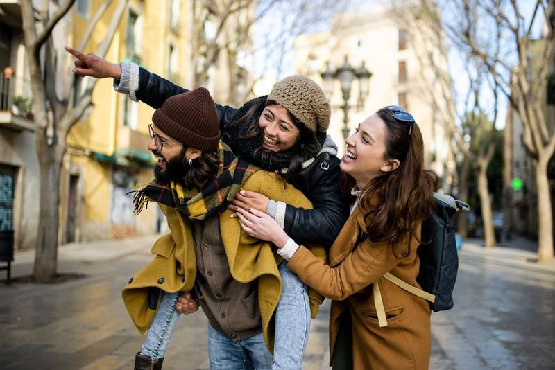 three happy young friends having fun in the city. Multiracial group smiling and looking at camera. Travel concept