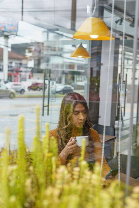 latin woman with long blonde hair sitting enjoying a cup of coffee in the morning, modern lifestyle