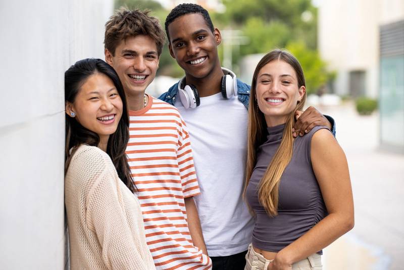 Beautiful young men and women smiling and looking at camera.Diverse group of joyful millennial people staring happy at camera.