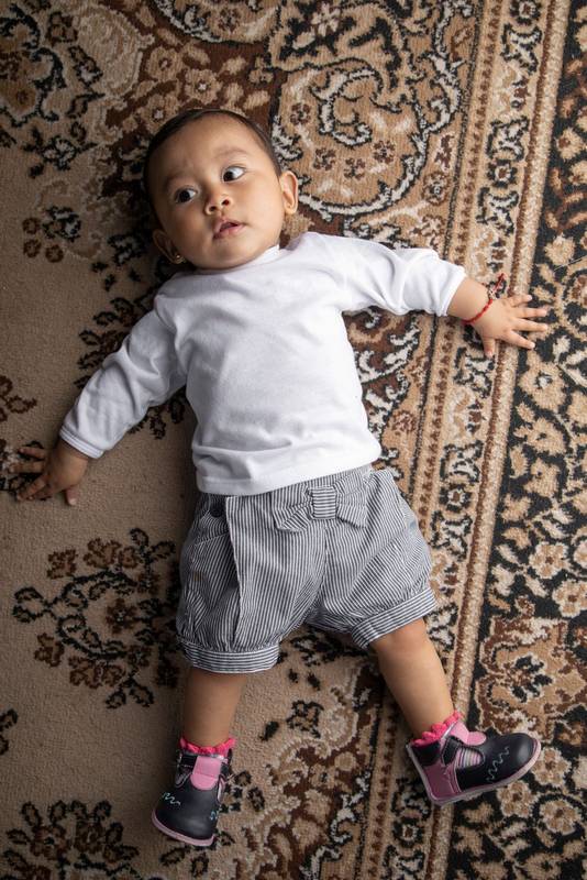 little boy lying on textured rug infant