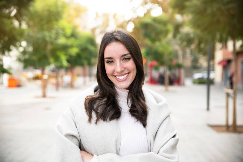 Portrait of young woman smiling happy standing at the city.