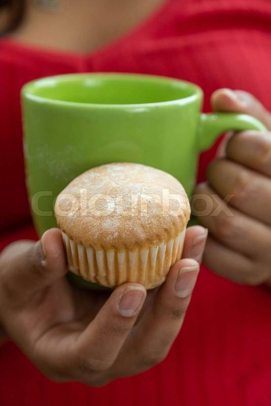 holding a green mug and a homemade cupcake, food and desserts