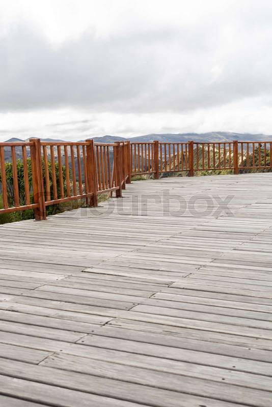 wooden bridge stretches across a serene natural landscape