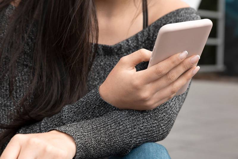 holding a smart cell phone in his hands, technology and connection