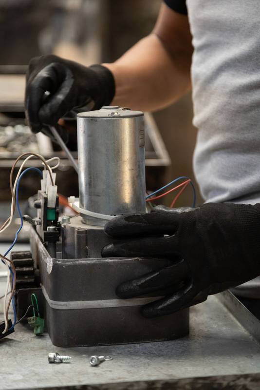 repairing a modern metal object that is on his workplace