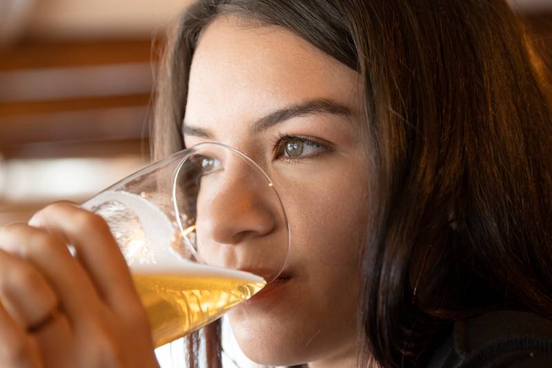 beautiful young woman with long hair, holding and drinking