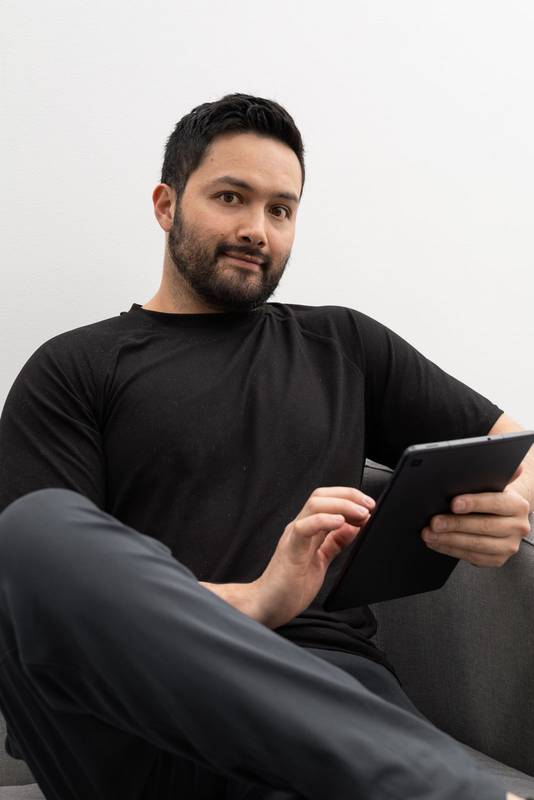 man Focused on his tablet, he appears to be reviewing professional content or reading