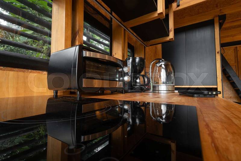 small electric bread oven placed in a stylish wooden glamping kitchen
