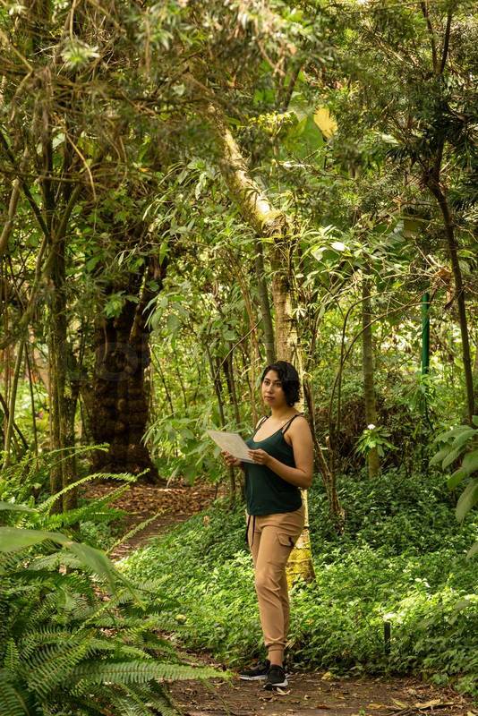 latin woman with short hair, standing in a forest, lifestyle in nature, travel