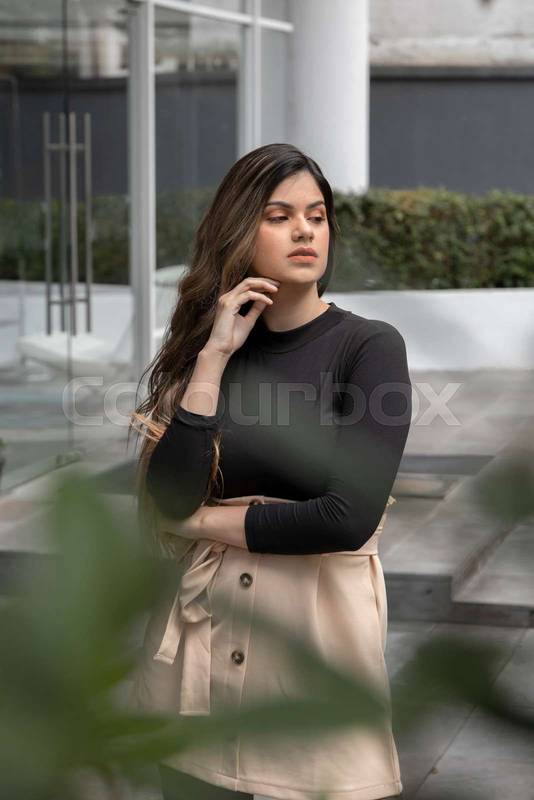 sunny day an attractive young woman in the street posing, she wears casual clothes