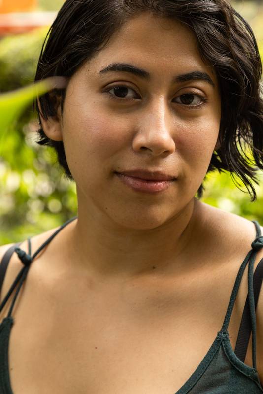 face of young latin woman with short hair, smiling and looking at the camera