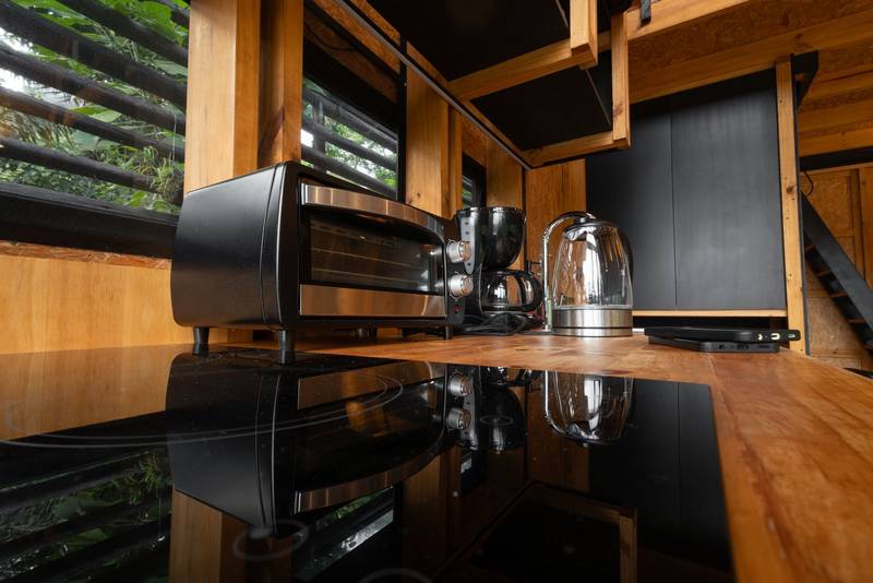 small electric bread oven placed in a stylish wooden glamping kitchen
