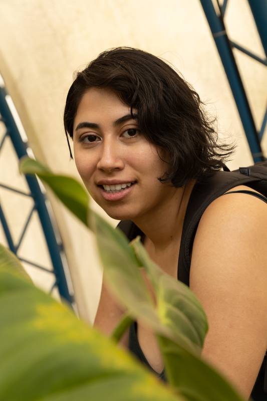 woman smiling with short black hair looking at the camera in a natural and casual way