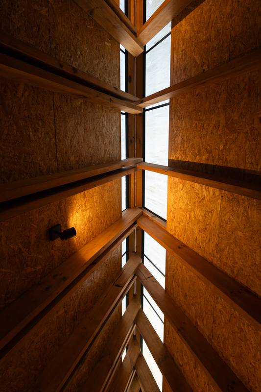 Slanted skylights in a triangular wooden roof let soft sunlight stream into the glamping space